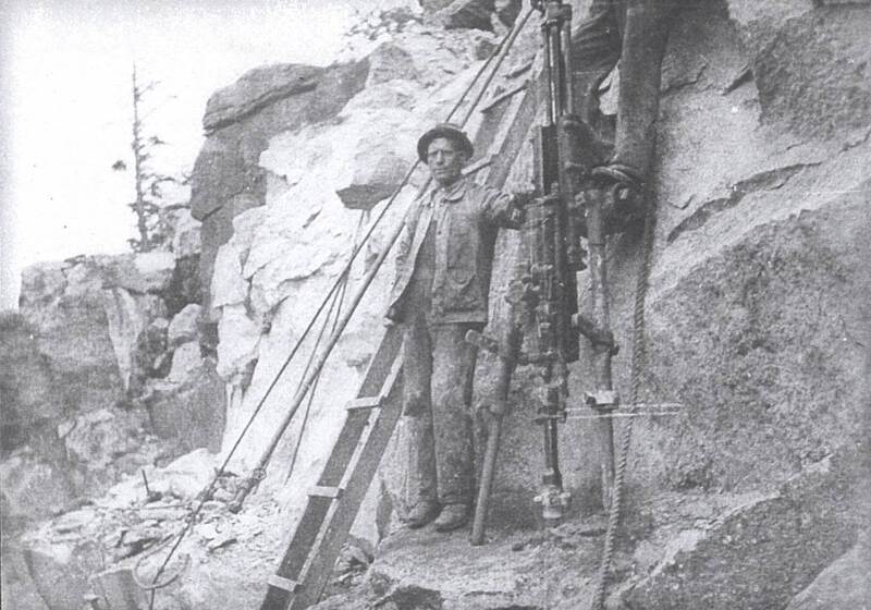 Worker stands by ladder at the Beattie Quarry Co. in Leete's Island