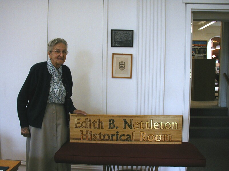 Edith B. Nettleton standing by the Historical Room Plaque