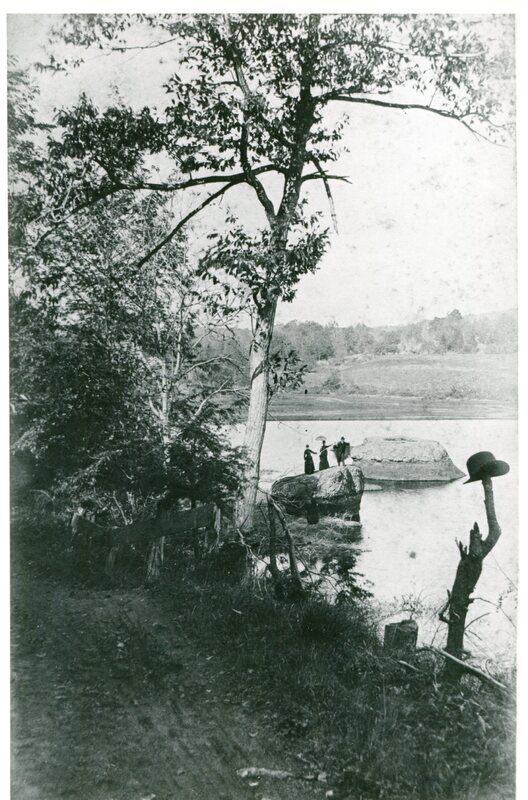 Three people wave from the rocks at Lake Quonnipaug